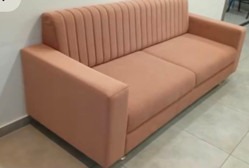 Peach three seater sofa with vertical stitching