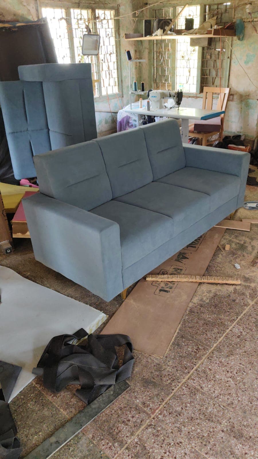 Blue three seater sofa in the workshop
